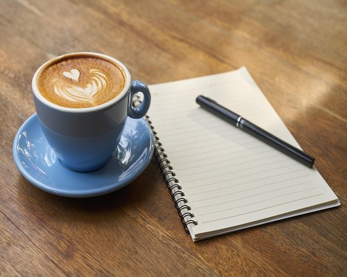 A warm cup of coffee and notes on a desk